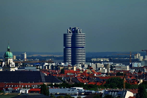 Munich, Germany - August 22, 2015: Panoramic view over Munich from the Alter Peter’s tower at the city center to the BMW  Headquarters building, located near by the Olympic Park. The tower represent four cylinders of a combustion engine.