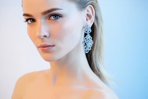 Portrait of nice looking woman with beautiful earings. Professional make-up