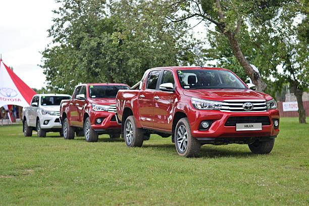 Toyota Hilux vehicles on the grass Poznan, Poland - July 7th, 2016: Presentation of a new Toyota Hilux on the press launch. The Hilux is one of the most popular pick-up vehicles in the world. toyota hilux stock pictures, royalty-free photos & images