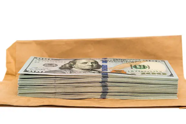 Photo of Isolated stack of hundred dollar bills on top of envelope