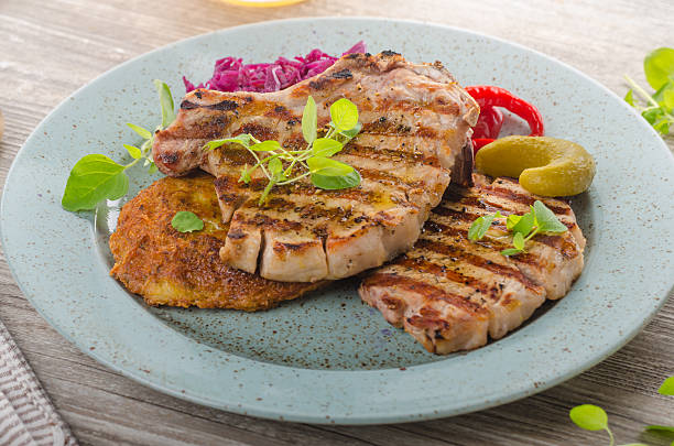 istock Grilled pork chops with herbs and garlic, potato pancakes 626907708