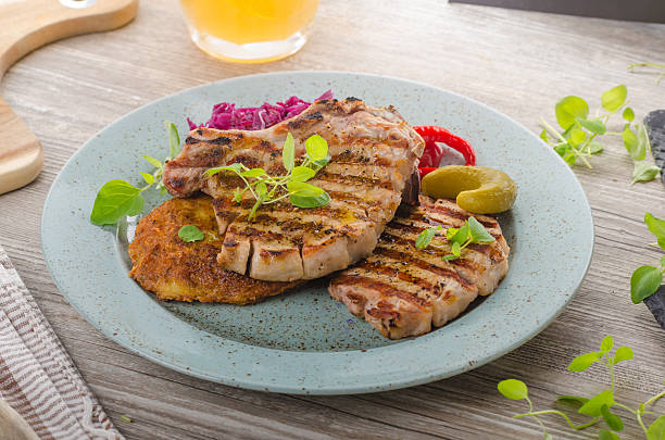 istock Grilled pork chops with herbs and garlic, potato pancakes 626907740