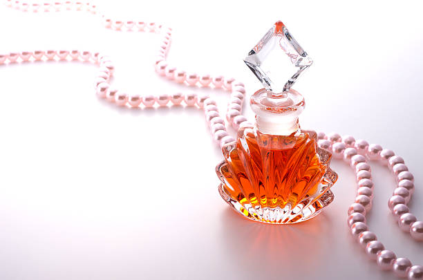 istock Perfume bottle and pearl jewellery on white background 626912504