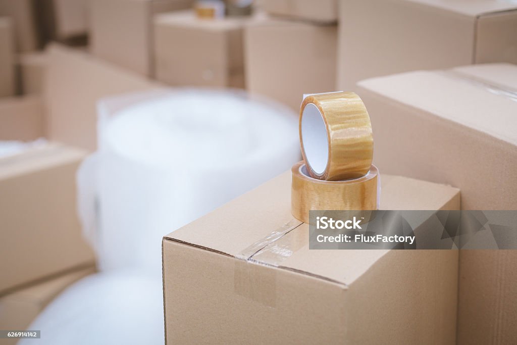 duct tape on cardboard box focus on duct tape close up in storage room Storage Room Stock Photo