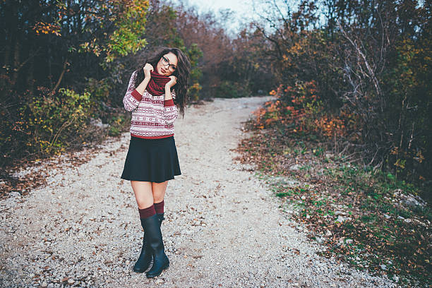 Young woman taking an autumn walk with her eyes closed in the forest. Copy space. Photographed in medium format.
