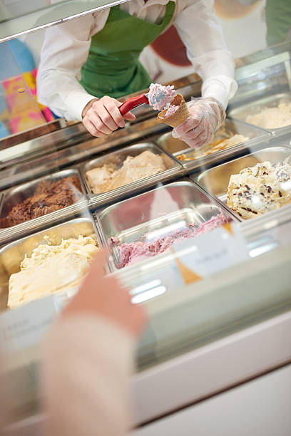 istock Filling cones with ice cream from glass case 626915522