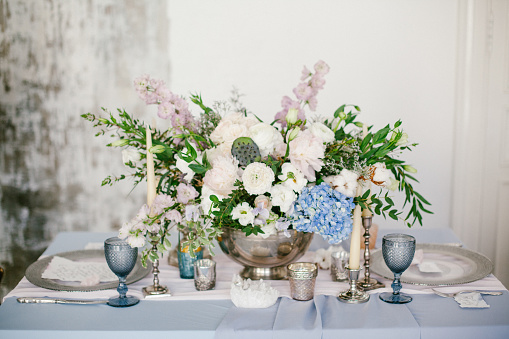 Silver candlestick and other elements of festive table wedding centerpieces decorations.