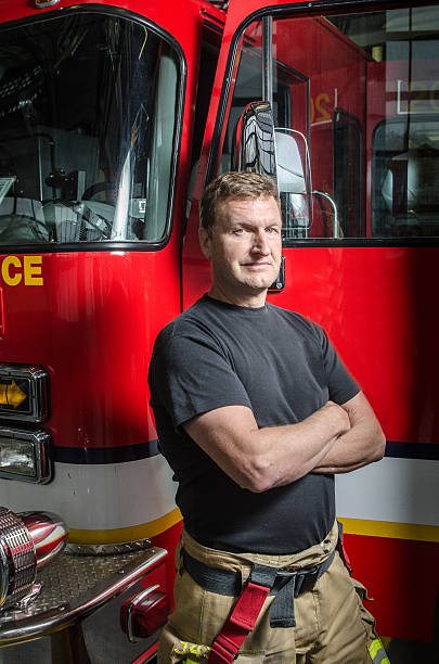 istock Fireman with arms crossed besides his truck 626915962