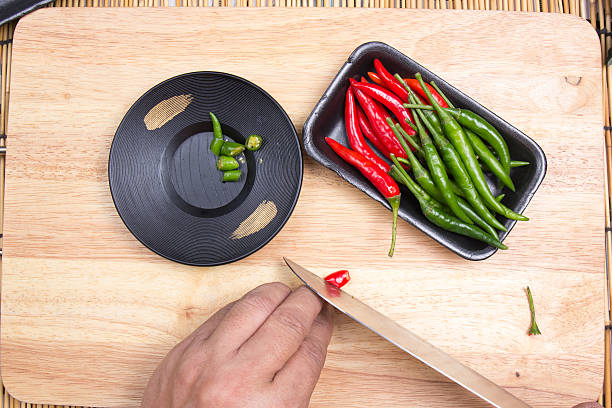 istock Hand cutting Hot Chili Peppers 626916870