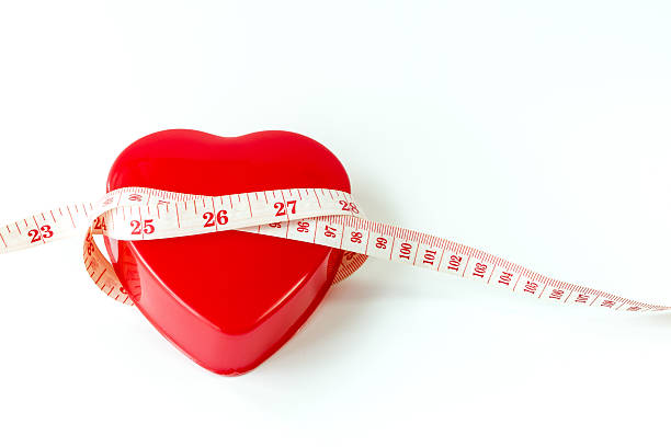 istock Measure tape around red heart isolated on white 626917134