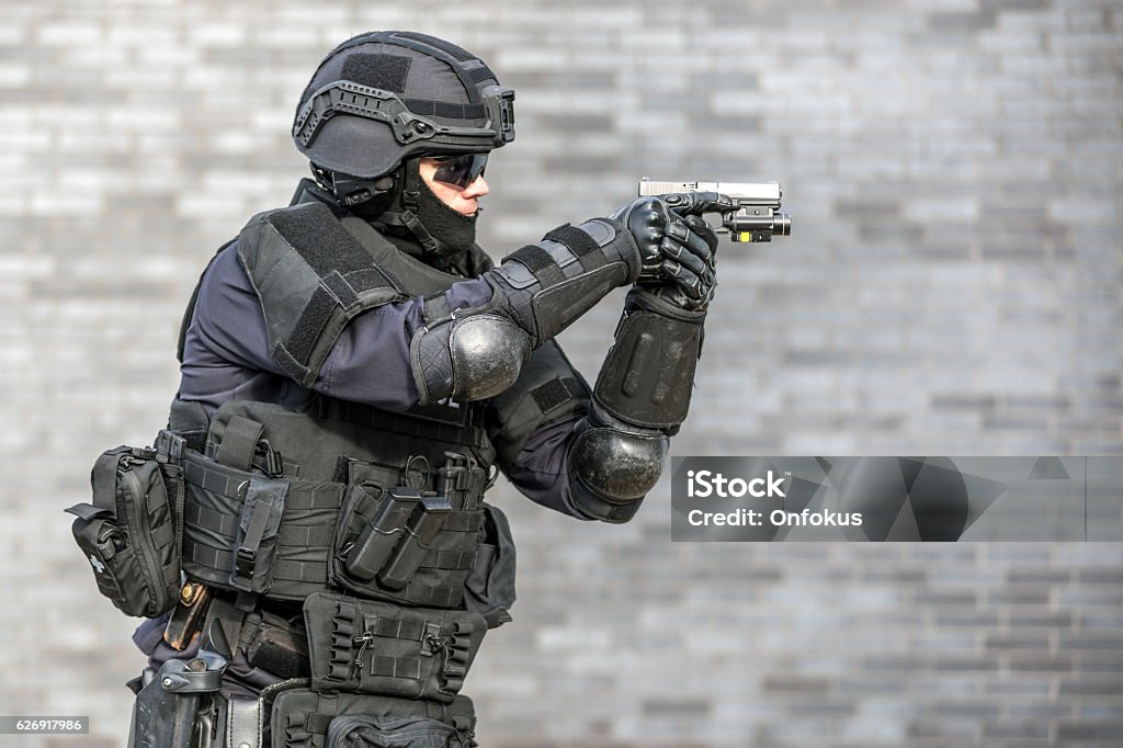 SWAT Police Officer Against Brick Wall Police Force Stock Photo