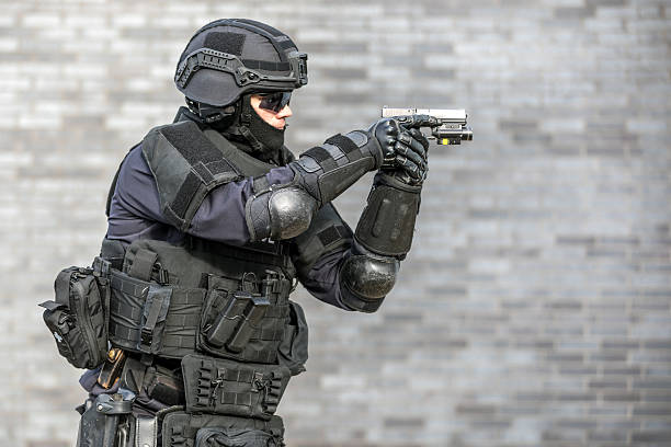 SWAT Police Officer Against Brick Wall SWAT Police Officer Against Brick Wall elbow pad stock pictures, royalty-free photos & images