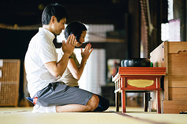 istock Japanese couple praying in a buddhist temple 626943912