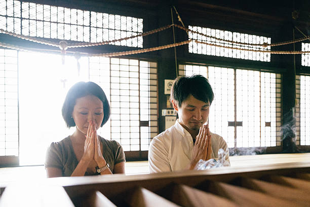 istock Japanese couple praying in a buddhist temple 626944152