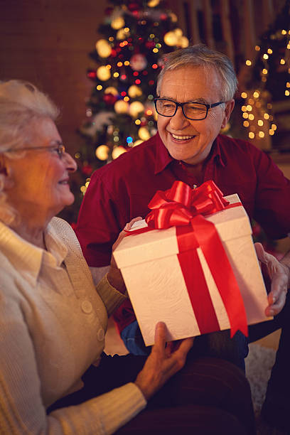 istock grandfather smiling and holding big gift 626954264