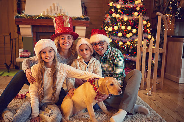 istock family and dog sitting by xmas tree 626954416