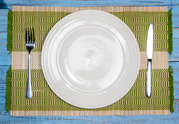 istock Blank plate with fork and knife on tablecloth background 626955296