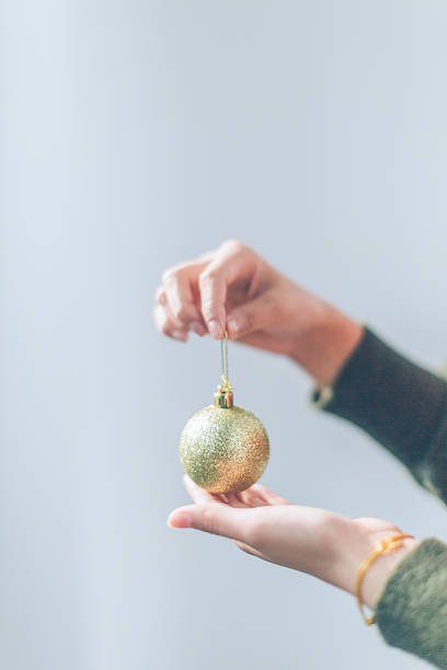 istock Beautiful woman with christmas bauble on a light background 626956456