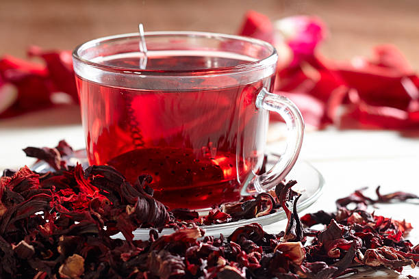 té de hibisco rojo en taza de vidrio - tea organic single flower flower fotografías e imágenes de stock