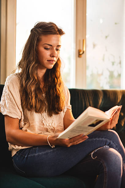 istock Young woman at home reading a book and relaxing. 626958508