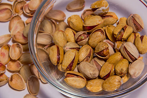 istock Pistachios nuts in glass bowl isolated on the white background 626961660