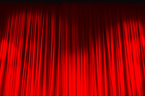istock Red closed curtain with light spots in a theater 626962720