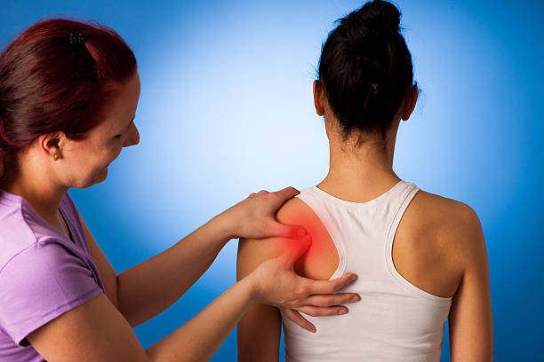 istock physio therapist helping Woman having pain in her back 626966818