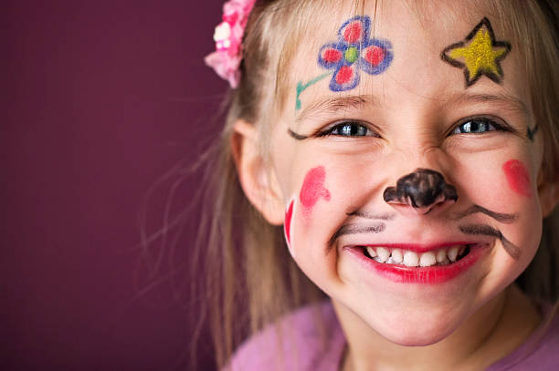 Smiling little girl with a painted face Closeup portrait of a smiling little girl with painted face. The cute girl is aged 4.  face paint stock pictures, royalty-free photos & images