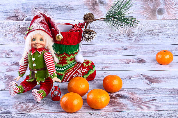 istock Christmas scene with elf, Christmas socks, tangerines and spruce 626996604