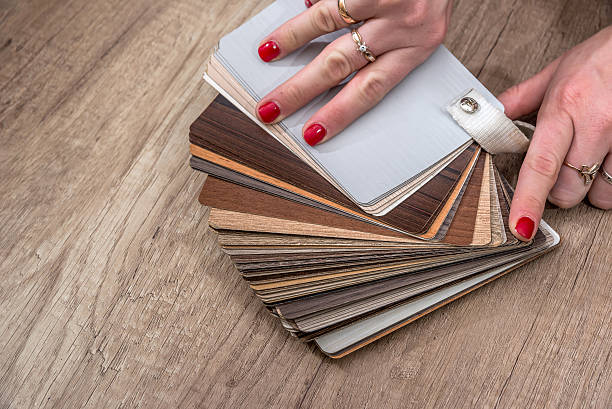 istock women showing Samples of laminate and vinyl floor tile 626997242