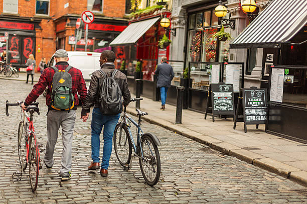 市内の自転車と混血ゲイカップル - dublin ireland urban road people real people ストックフォトと画像