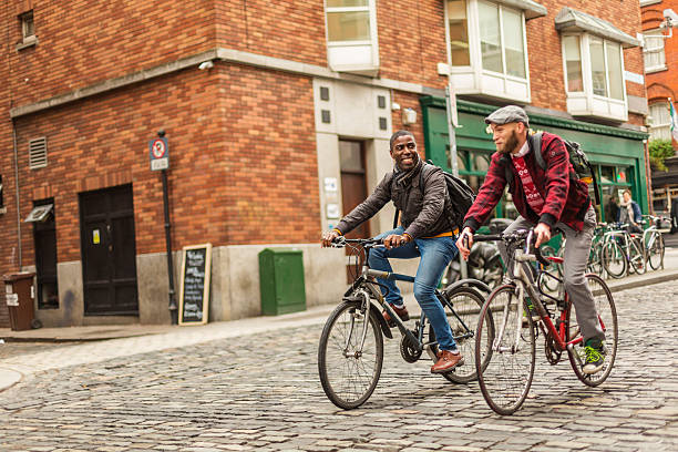 pareja gay de raza mixta con bicicletas en la ciudad - dublín fotografías e imágenes de stock