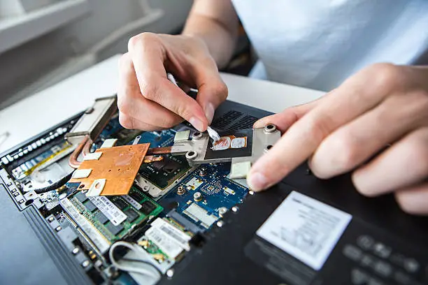 Photo of man repairing a computer. laptop clean thermal