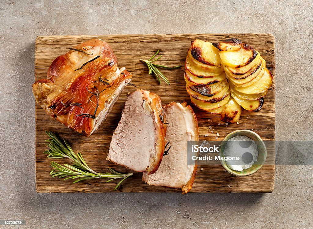 roasted pork slices roasted pork slices and potatoes on wooden cutting board, top view Pork Stock Photo