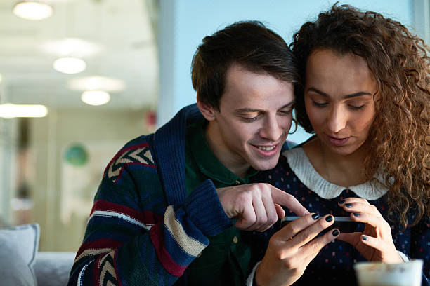 istock Young couple scrolling through photos on smartphone 627001422