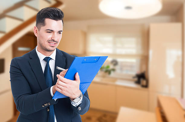 istock Young Real Estate Agent writing on clipboard 627012132