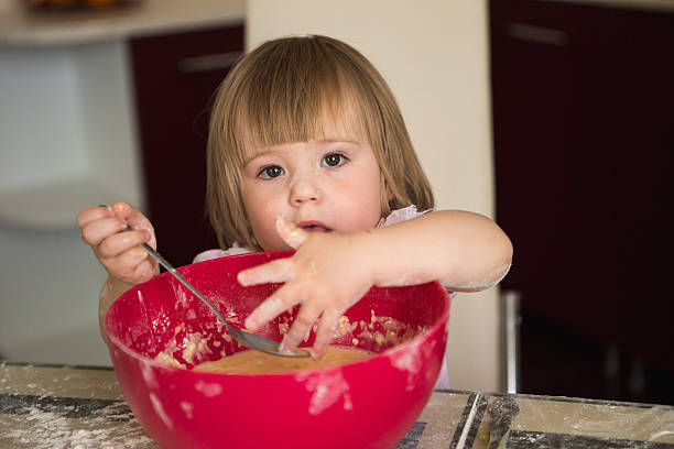 istock Little girl mixing dough 627014018