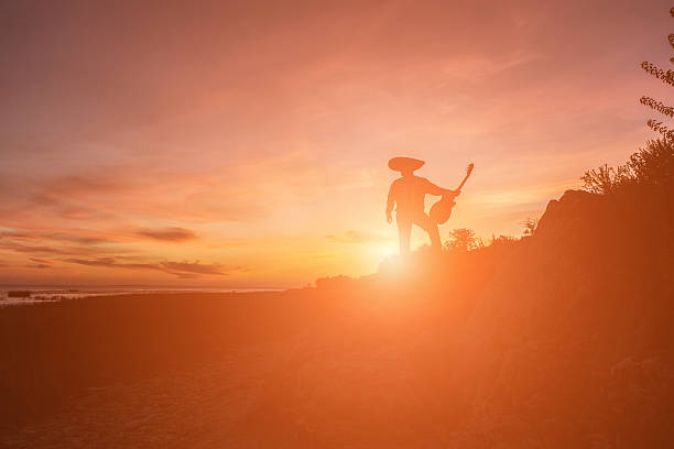 Musician on the coast. Mexican, Latin American, Spanish. Silhouette, dark, evening