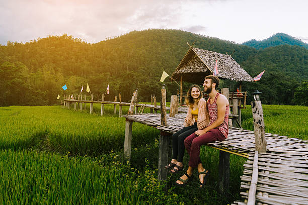 Couple on the bamboo bridge near rice field Young Caucasiasn couple on the bamboo bridge near rice field, Thailand  bamboo bridge stock pictures, royalty-free photos & images