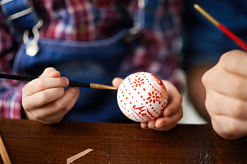 Hands of little boy painting Christmas ball