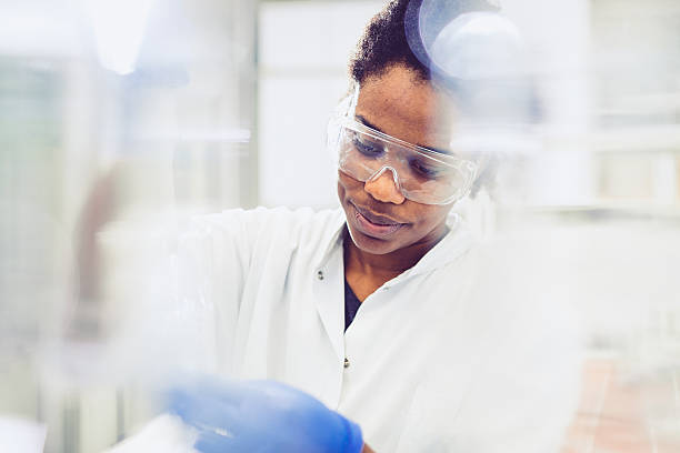 молодая женщина-ученый, работающая в лаборатории - scientist chemist doctor lab coat стоковые фото и изображения