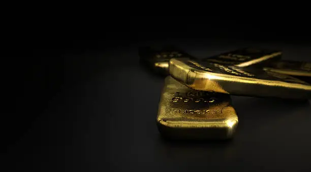 3D illustration of gold bullion bars over black background with copyspace on the left,  horizontal image. Gold market concept.