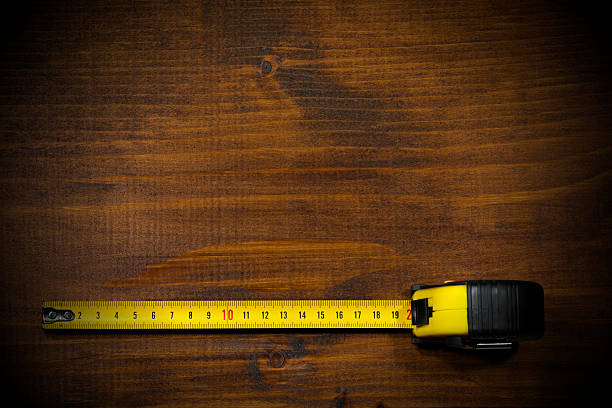 tape measure on a wooden work table - tape measure home improvement measuring wood imagens e fotografias de stock