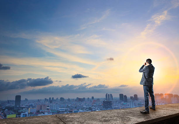 business man and binocular spying on top of building