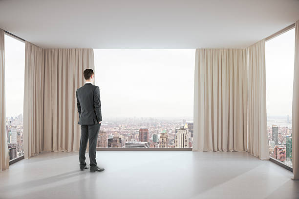 istock Man in room with city view 627034590