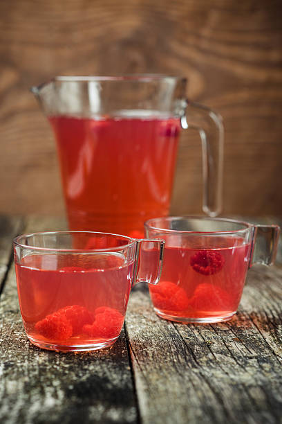 istock Berries compote in glass jar , two cup on wooden background. 627035474