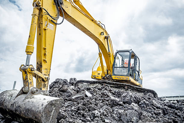 excavadora está preparando la pila de tierra para la carga en el camión. - moviendo hacia abajo fotografías e imágenes de stock