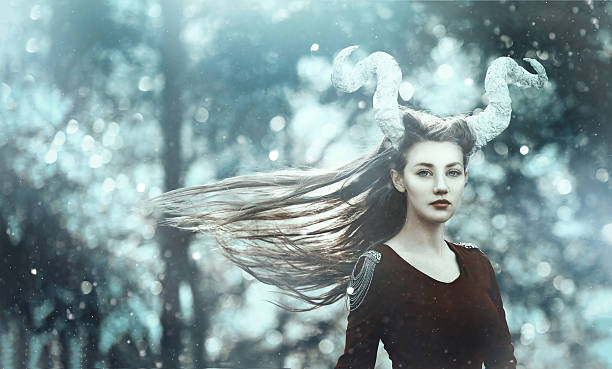 fairy demon with horns horizontal shot of demon woman with horns posing in the woodland, looking at camera with nostagic expression. astrology sign photos stock pictures, royalty-free photos & images