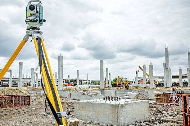 Geodesist device on tripod is connected with total station. Surveyor instrument is for measuring level on construction site. Surveyors ensure precise measurements before undertaking large construction projects. geodesic dome stock pictures, royalty-free photos & images