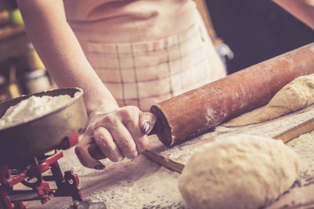istock Close up of female baker hands kneading dough. 627044186
